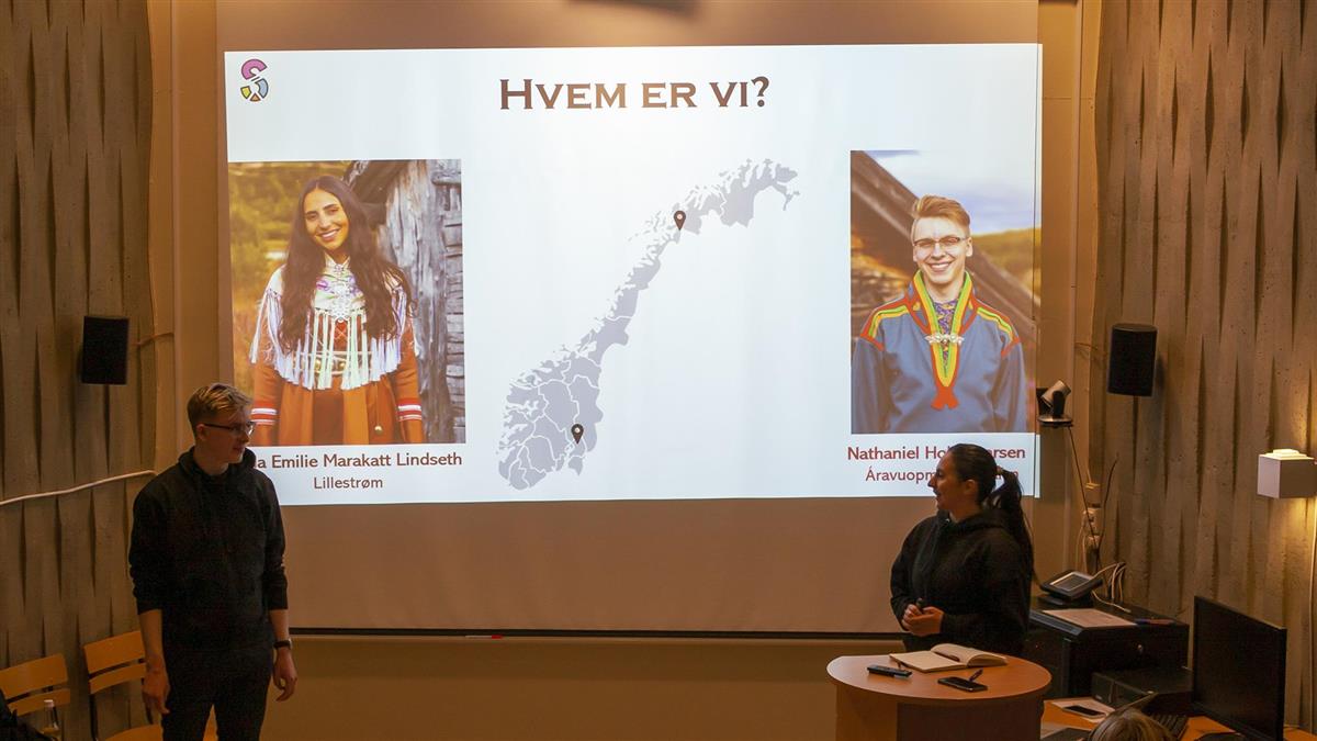 De to samiske veiviserne står foran prosjektorbildet og presenterer hvem de er og hvor de kommer fra på auditoriet på studiested Solhaugen,. - Klikk for stort bilde