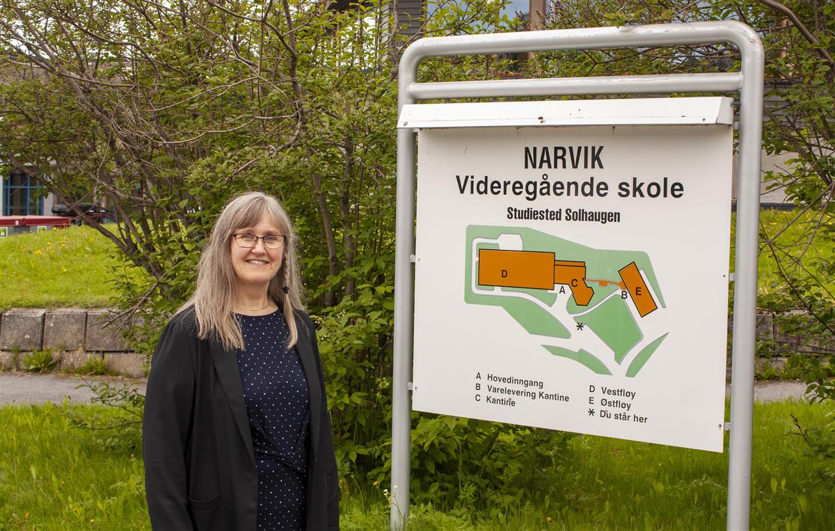 Rektor Anita Merete Sletbakk foran skiltet til studiested Solhaugen. - Klikk for stort bilde