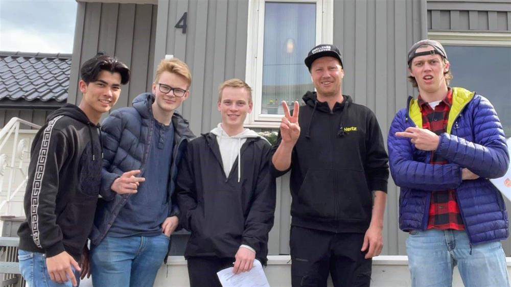 Fem personer poserer foran et hus i Narvik - Klikk for stort bilde